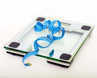 blue tape measuring on clear glass square weighing scale